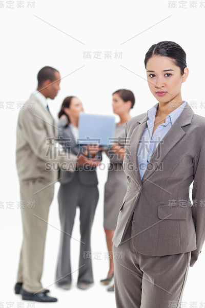 严肃的女商人站在后面，还有同事