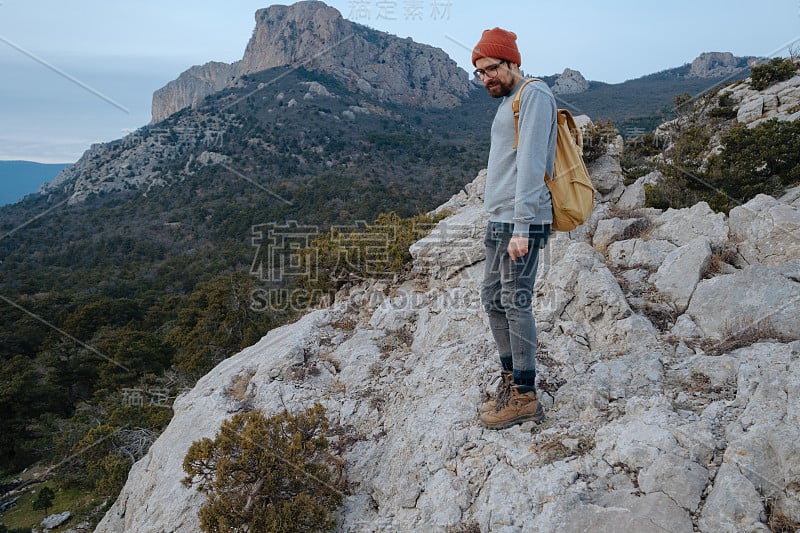 男人背包徒步旅行和红帽子在山区