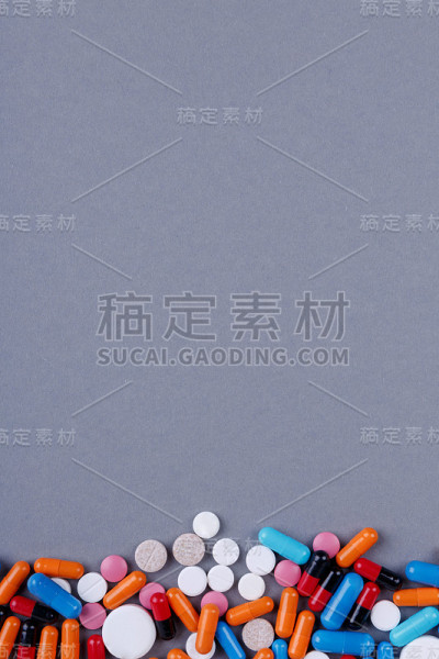 在一个灰色的背景和一个地方的碑文是一堆药丸。医学的概念。