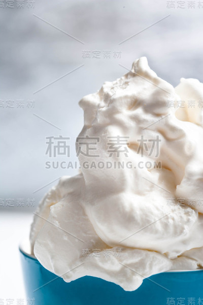 香草软冰淇淋在蓝色的碗在明亮的背景。