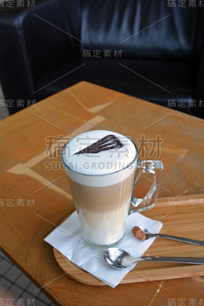 木桌上的杯子上的玛奇朵拿铁