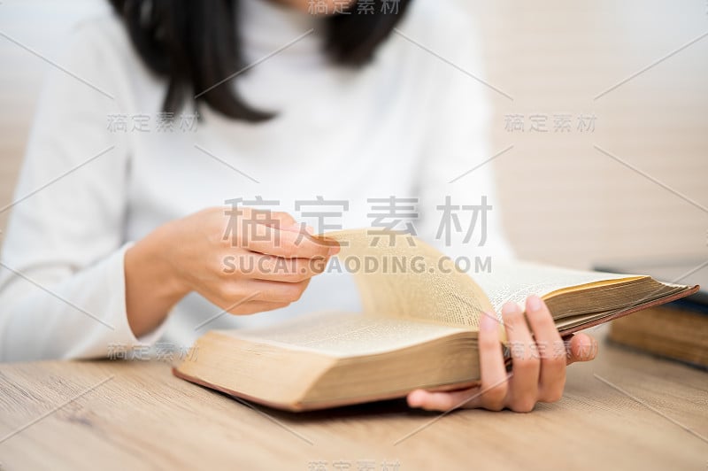 一位穿着白衬衫的亚洲女学生坐在大学里读书