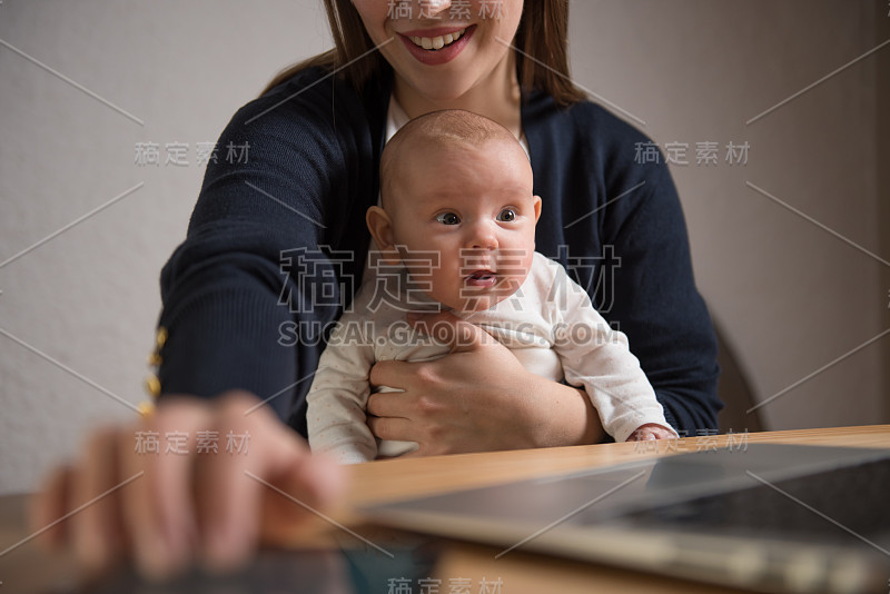 非常可爱的小女孩看着笔记本电脑的屏幕