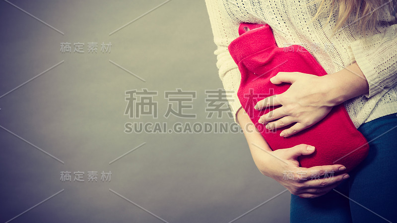 女人拿着热水瓶感觉胃痉挛