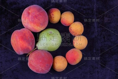 桃子，杏和梨水果拼盘在一个黑暗的背景