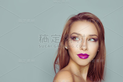 思考,做白日梦。一个美丽女孩的肖像，看着一边。孤立在浅蓝灰色背景