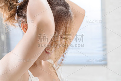 近距离的微笑女人化妆刷近脸和看镜子。亚洲美女