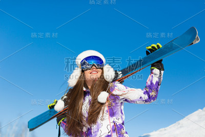 山顶上一个带着滑雪板的女人。