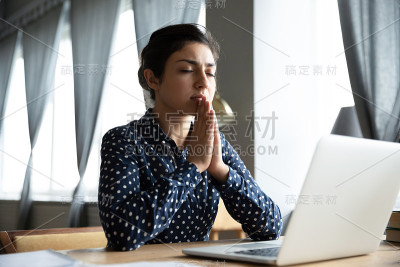 虔诚的印度女孩在工作场所向上帝祈祷