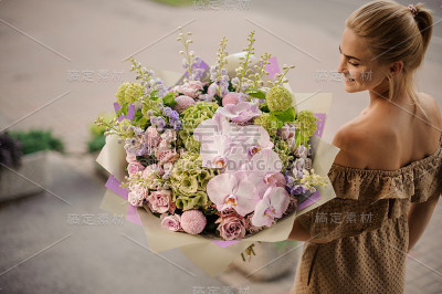 高角度的金发女人与大华丽的捧花在她的手中