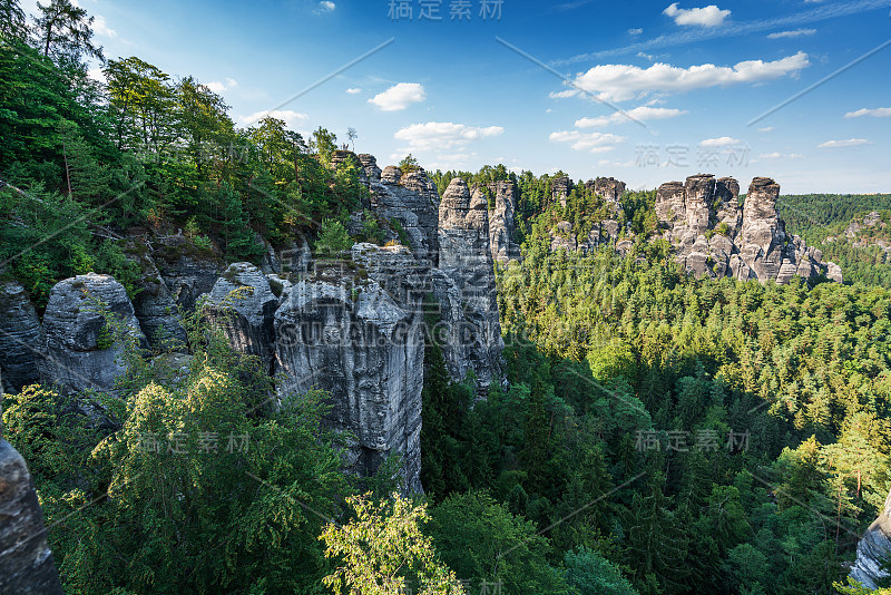 瑞士波西米亚的坏山道。巴斯蒂桥和山景。狭窄的岩石，天然的砂岩拱门在欧洲。有绿色植物、蓝天和阳光的山景