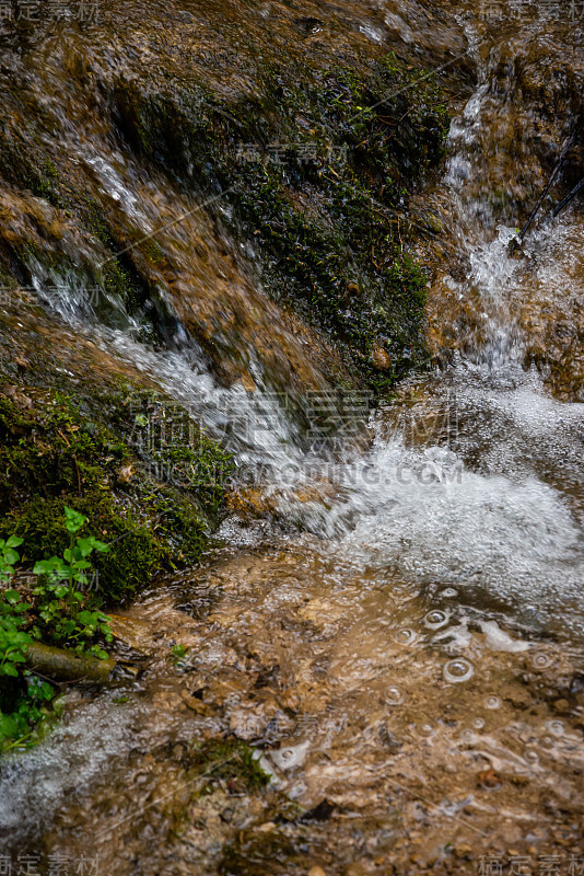 美丽的高山雨林瀑布与快速流动的水和岩石，长时间暴露。自然季节性的户外旅游背景与阳光时兴