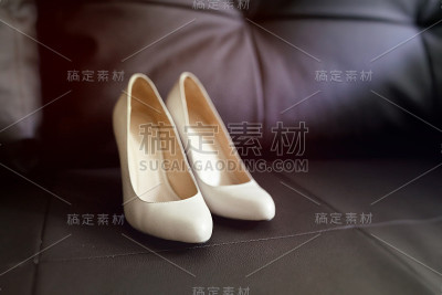 婚礼鞋放在棕色的皮沙发上