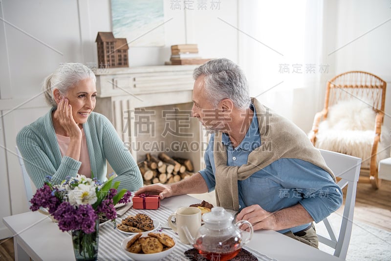 白发男子在早餐时给妻子送礼物