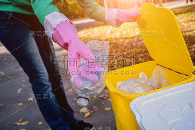 志愿者女孩在公园的街道上分类垃圾。回收的概念。