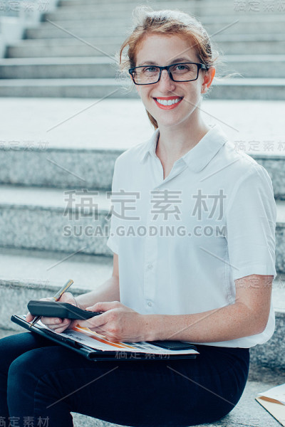 微笑着在楼梯上工作的商业女性