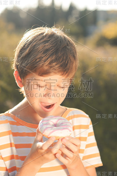 男孩在户外吃甜甜圈