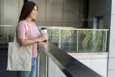 年轻漂亮的女人拿着一个白色的帆布包