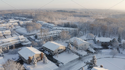 鸟瞰图的住宅，公寓，联排别墅覆盖雪在冬季。建立拍摄美国社区，郊区的冬季。中西部的房地产，阳光明媚的早