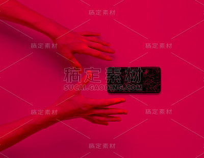 情绪化的手和一个坏掉的智能手机。粉色霓虹灯