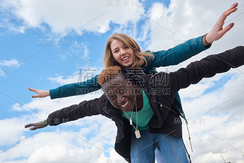 年轻的国际夫妇在天空背景。非洲人和白种人