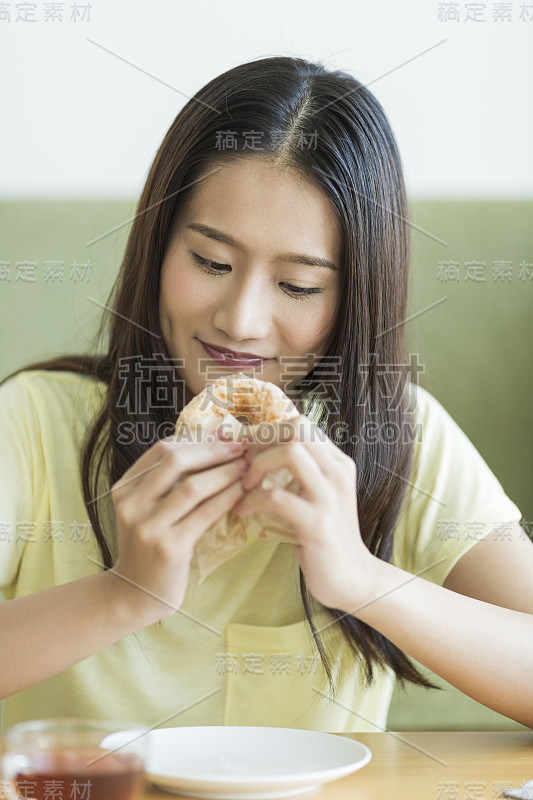 年轻女子在吃甜甜圈