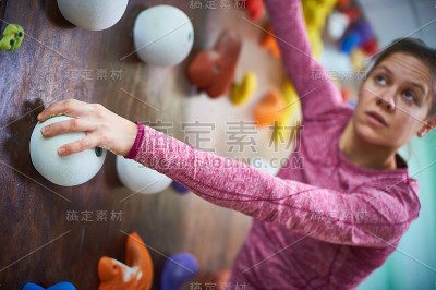 在攀岩大厅的运动女性。专注于一只手