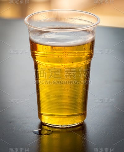 桌上放着塑料杯里的新鲜啤酒