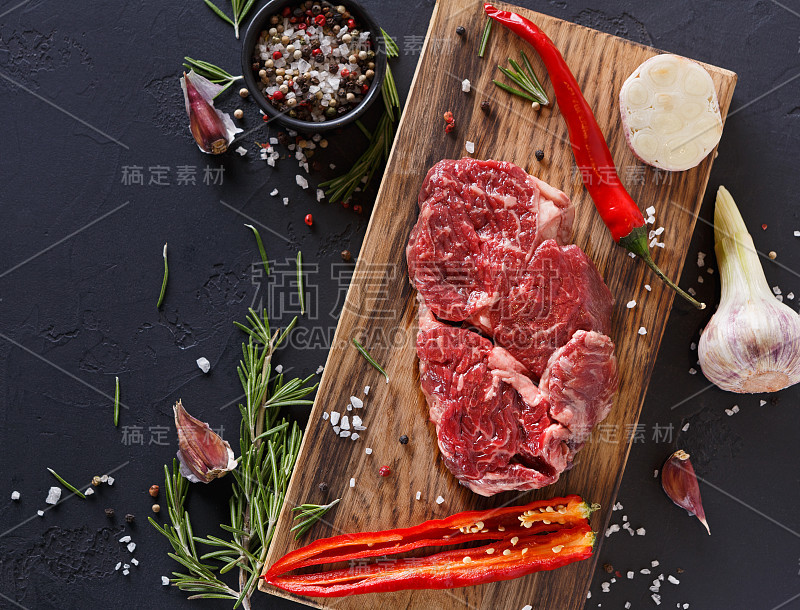肋眼牛排和香料在木材上的黑色背景
