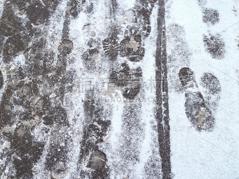 雪地上柏油路上结冰的人的足迹