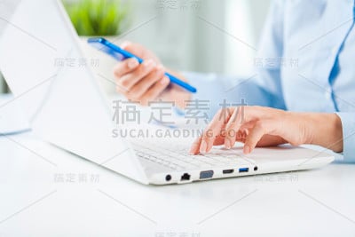 年轻的商业女性使用笔记本电脑工作