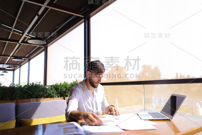 市场经理使用统计文档和笔记本电脑