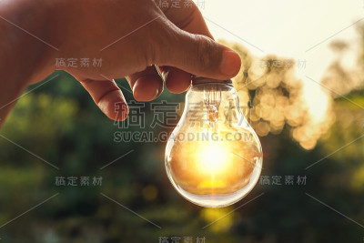 能量的概念与手持灯泡的能量和自然界的日落