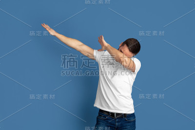 蓝色画室背景上的白人青年肖像