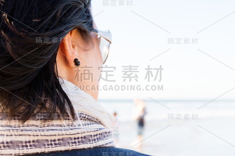 后视镜的女人度假在海滩上看地平线