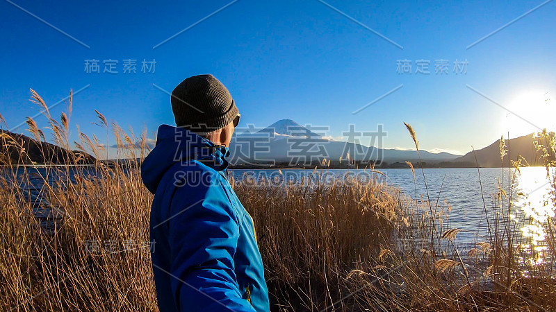 日本——一名男子站在川口湖边，眺望富士山