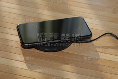 桌子上的黑色手机正在无线充电