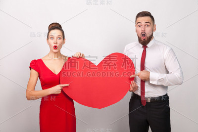 哇!大爱。一对好奇的夫妇用手指着红色的耳朵