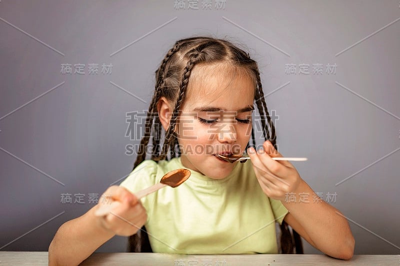 女孩用茶匙倒热巧克力液体，巧克力从来就不多