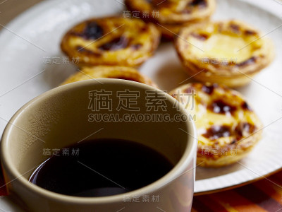 软焦蛋挞在一个盘子和黑咖啡杯