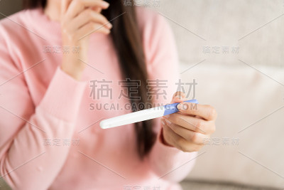 怀孕测试呈阳性的女性，注意前景的两条条纹。