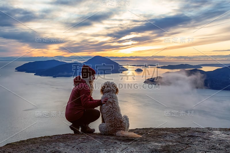 爱冒险的女孩带着狗在山顶徒步旅行