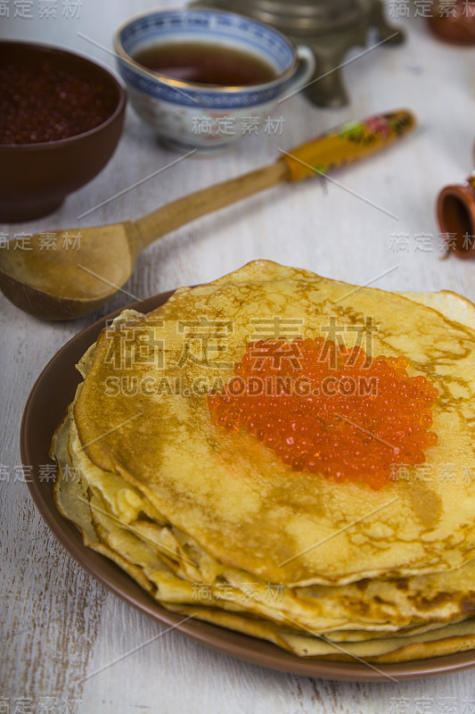 桌子上有煎饼和红鱼子酱。