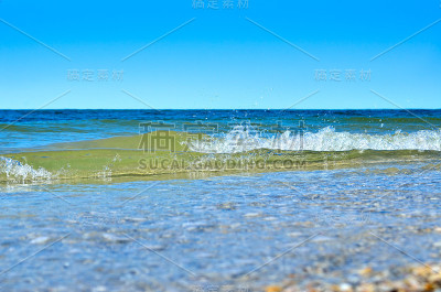 海浪冲刷干净的海滩上的贝壳。野生海滩上的风景。