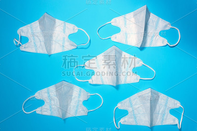 蓝色背景的医用口罩。从上面看，是平坦的。医学概念。