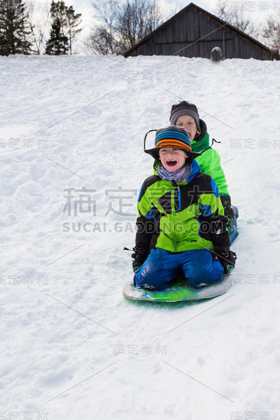 男孩们骑着雪橇，在雪地上滑行