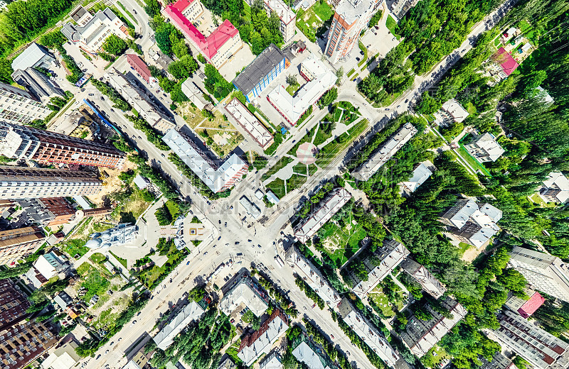 空中城市景观十字路口和道路，房屋，建筑物，公园和停车场。阳光明媚的夏日全景图