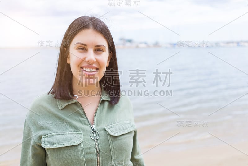 年轻漂亮的女人在海滩上笑得很开心