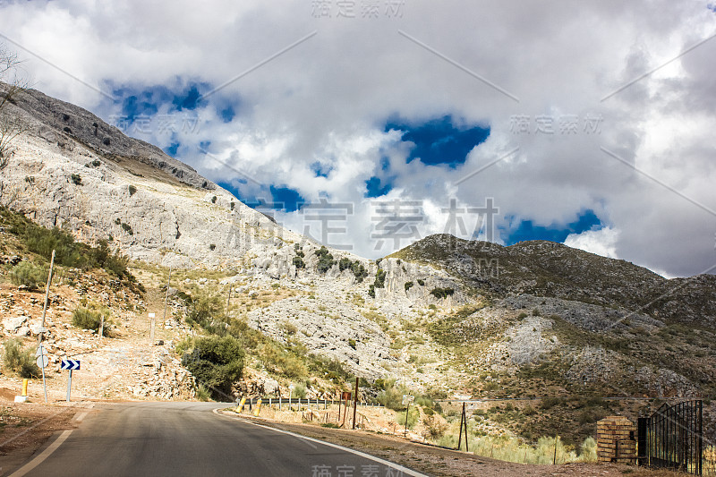 山景上的蓝色多云的天空背景。风景如画的群山在阳光下闪闪发光。令人屏息的自然影像