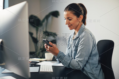 微笑的女商人在用手机发短信